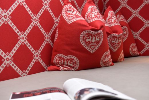 Ein rotes Sofa mit einem weißen Muster und einem offenen Buch